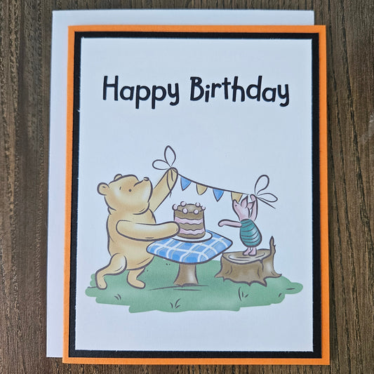 Birthday card with cartoon characters and 'Happy Birthday' text on a wooden surface