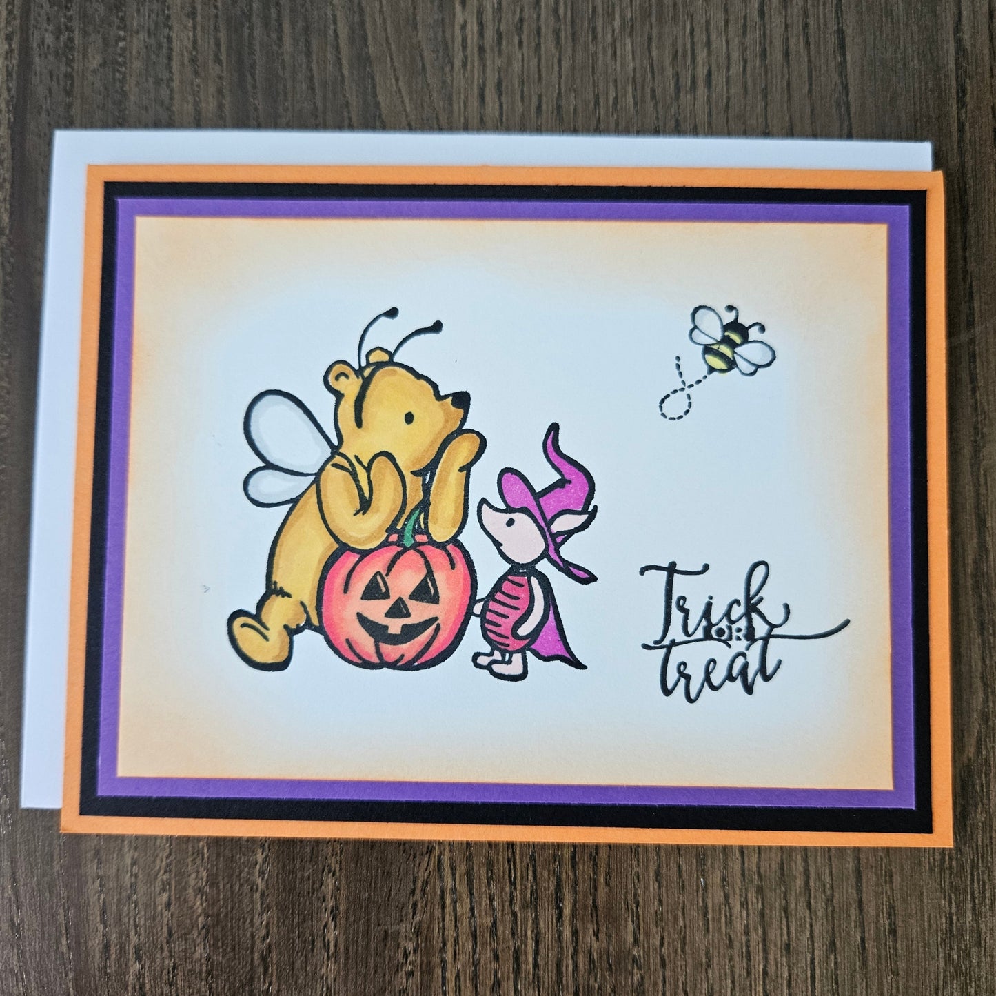 Halloween-themed greeting card with a dog in a pumpkin costume and text on a wooden surface
