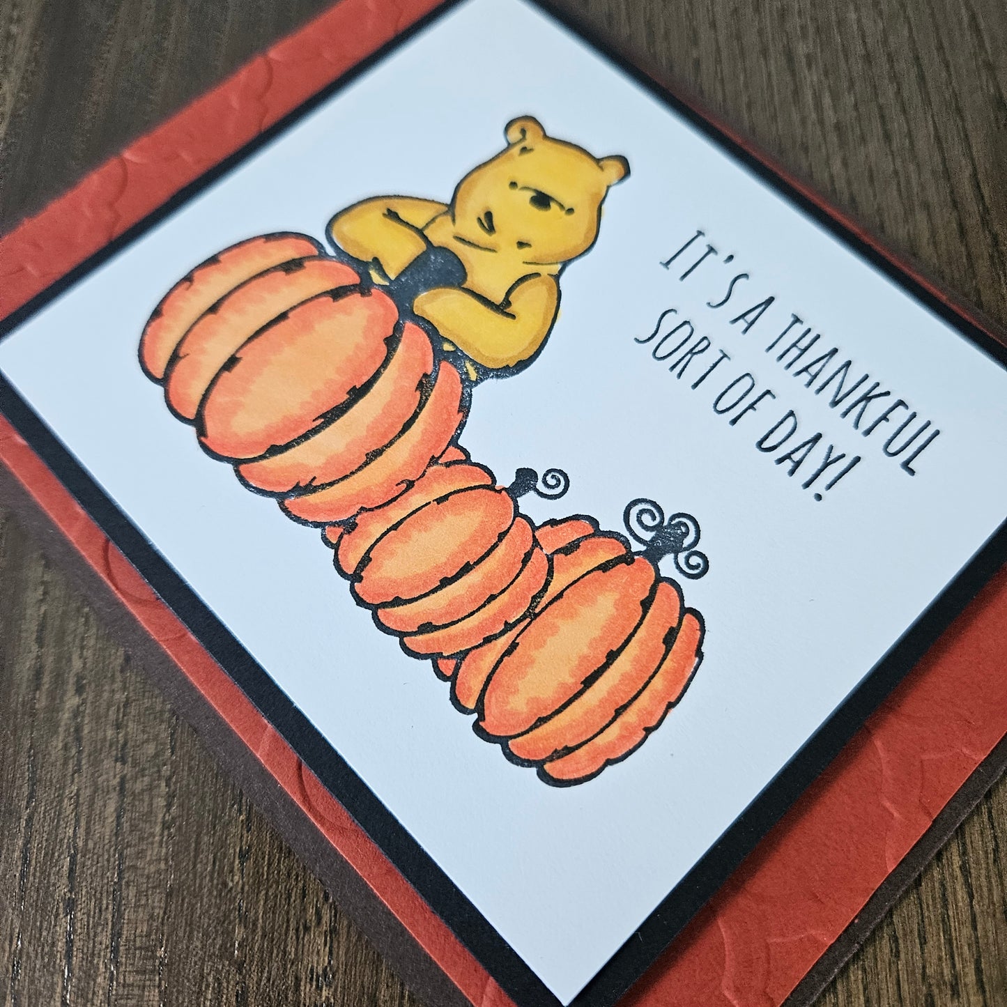handmade horizontal A2 Thanksgiving card featuring classic Winnie the Pooh with three orange pumpkins on a white panel, an embossed textured orange mat, and a brown base, alongside views of the "HAPPY Thanksgiving" inside text 