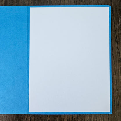 Blue card with white interior on a wooden surface