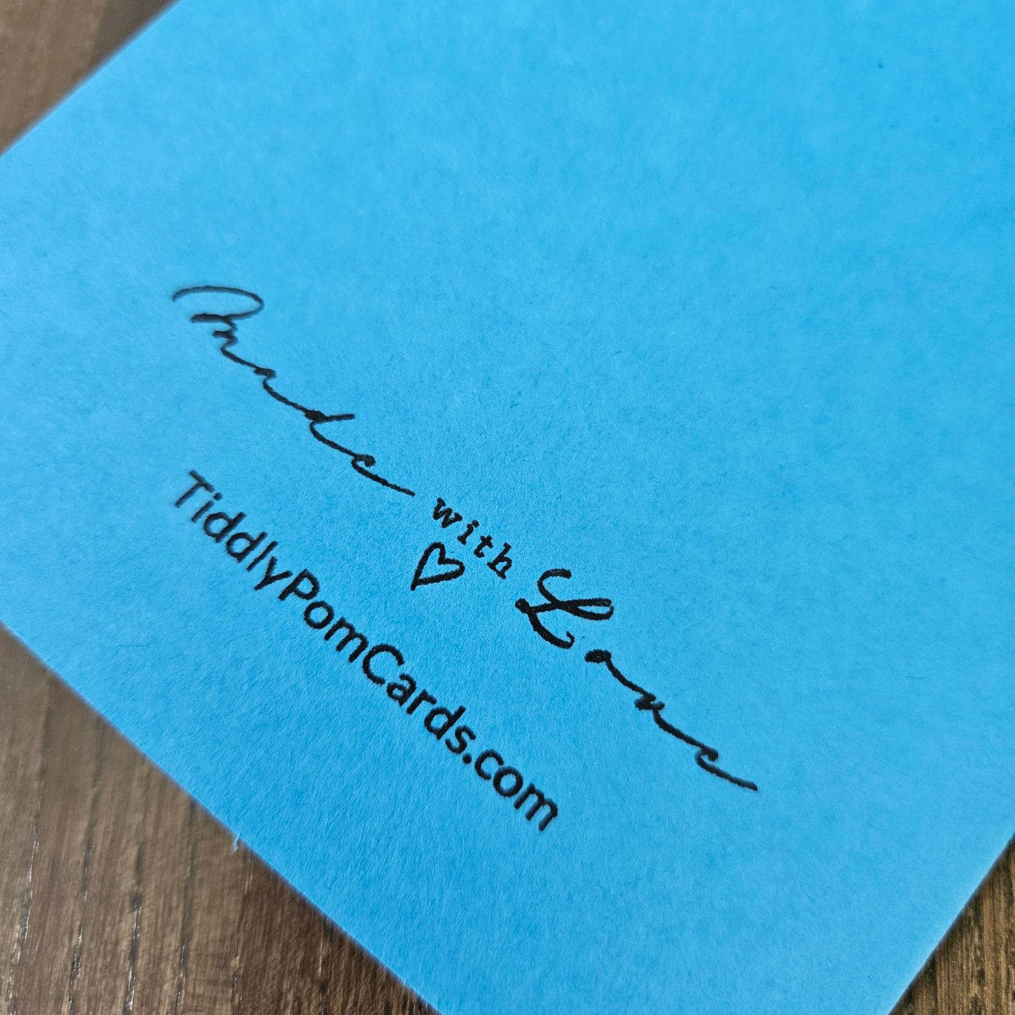 Blue card with 'Made with Love' and TiddlyPomCards.com text on a wooden surface