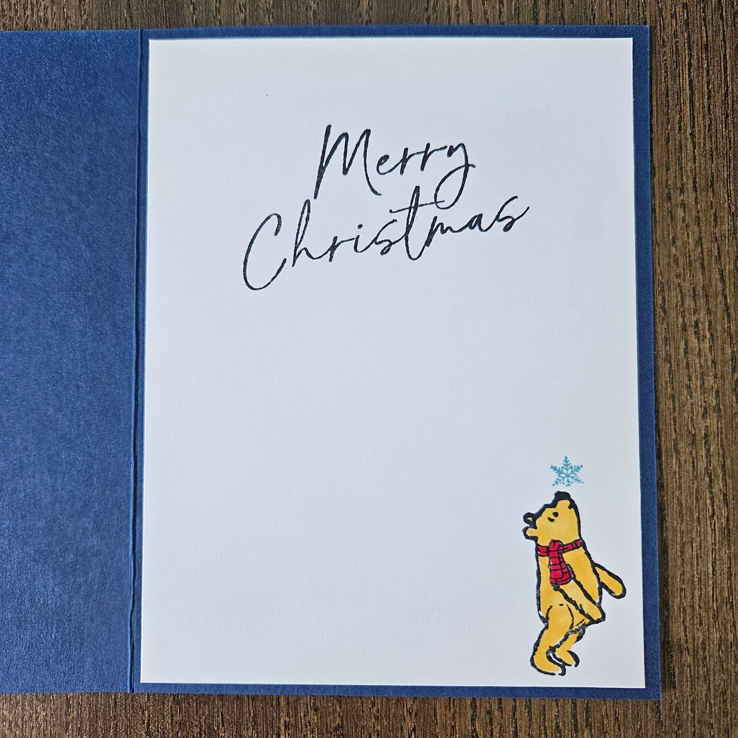 Christmas card with a bear illustration and 'Merry Christmas' text on a blue and white background.