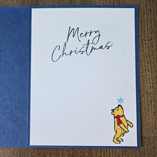 Christmas card with a bear illustration and 'Merry Christmas' text on a blue and white background.