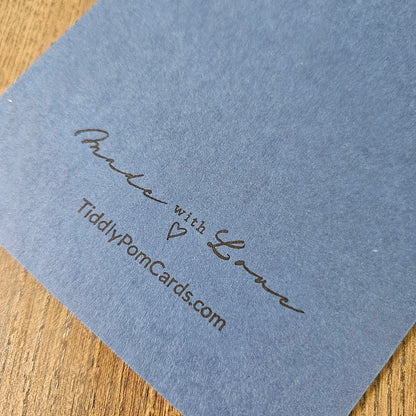 Blue card with 'Made with Love' and TiddlyPomCards.com text on a wooden surface