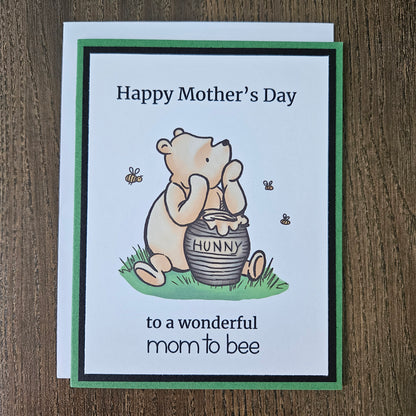 Winnie The Pooh Mother's Day card for mom to be holding a honey pot and text on a beige background
