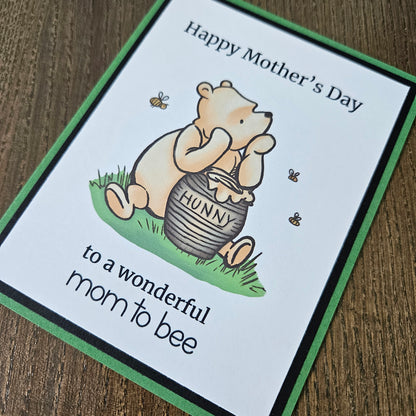 Winnie The Pooh Mother's Day card for mom to be holding a honey pot and text on a beige background