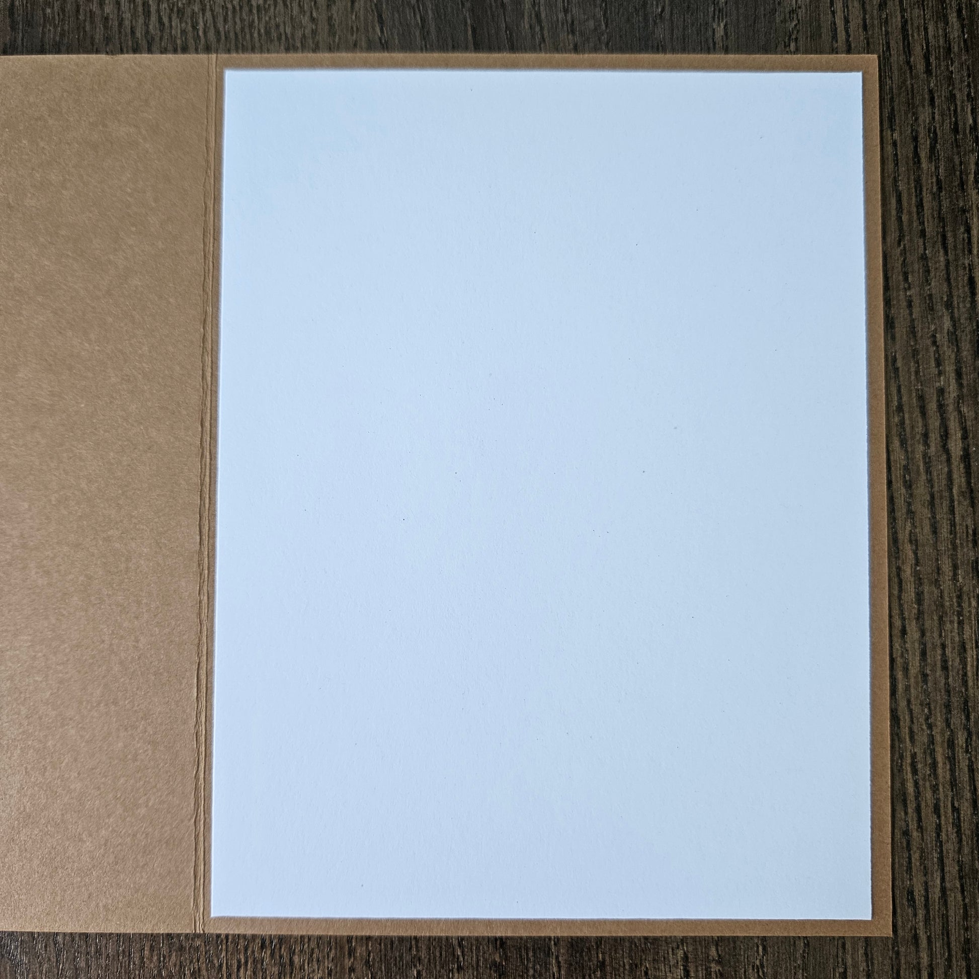 Card with light blue interior and brown exterior on a wooden surface