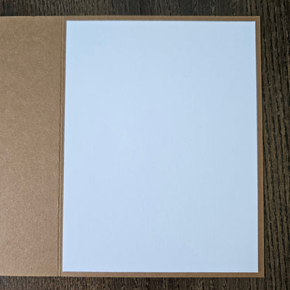 Card with light blue interior and brown exterior on a wooden surface