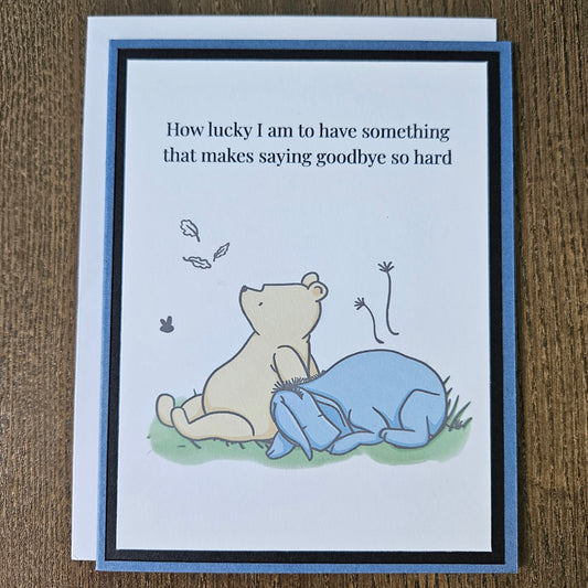 Card with a bear and cloud illustration and text on a wooden surface