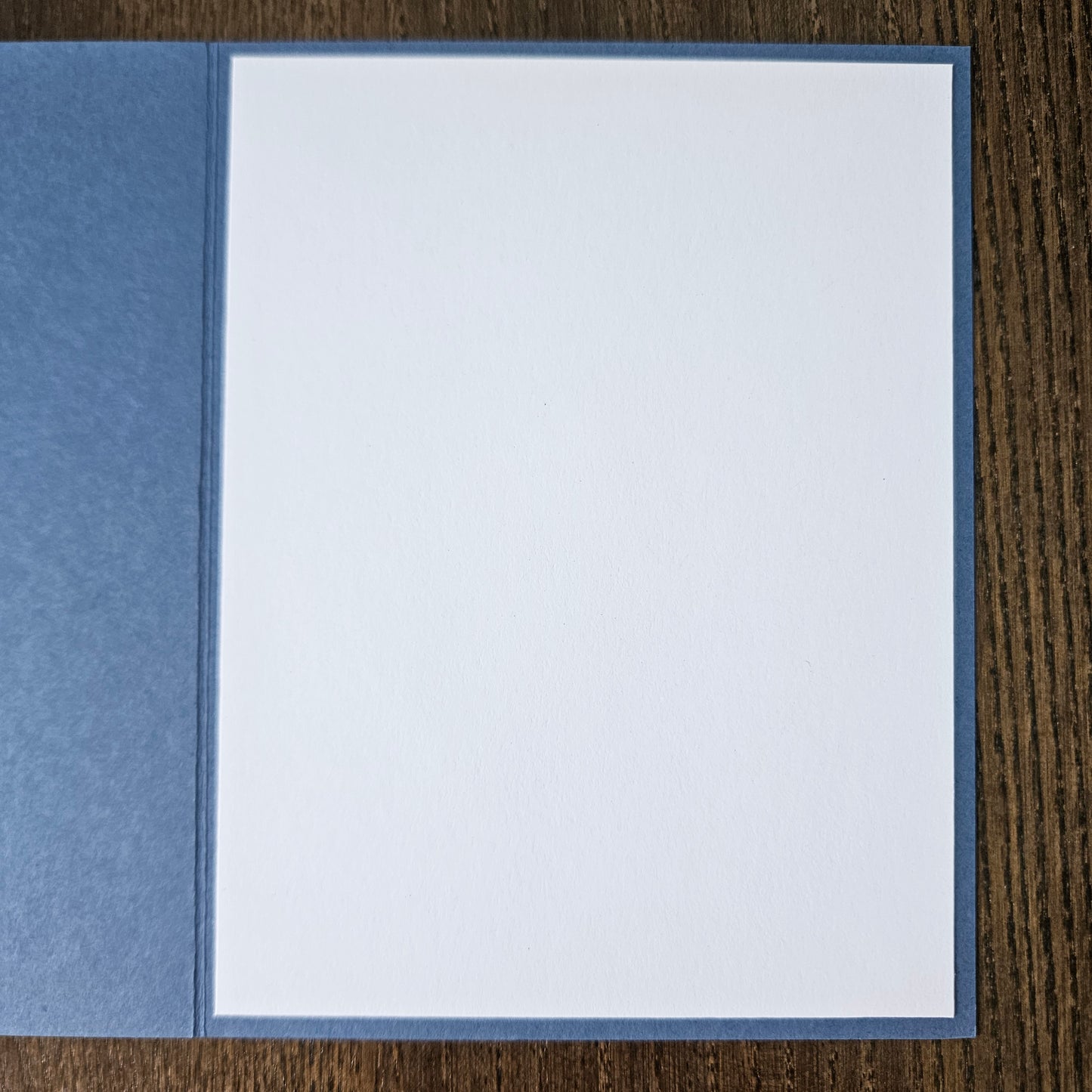 White card with blue border on a wooden surface