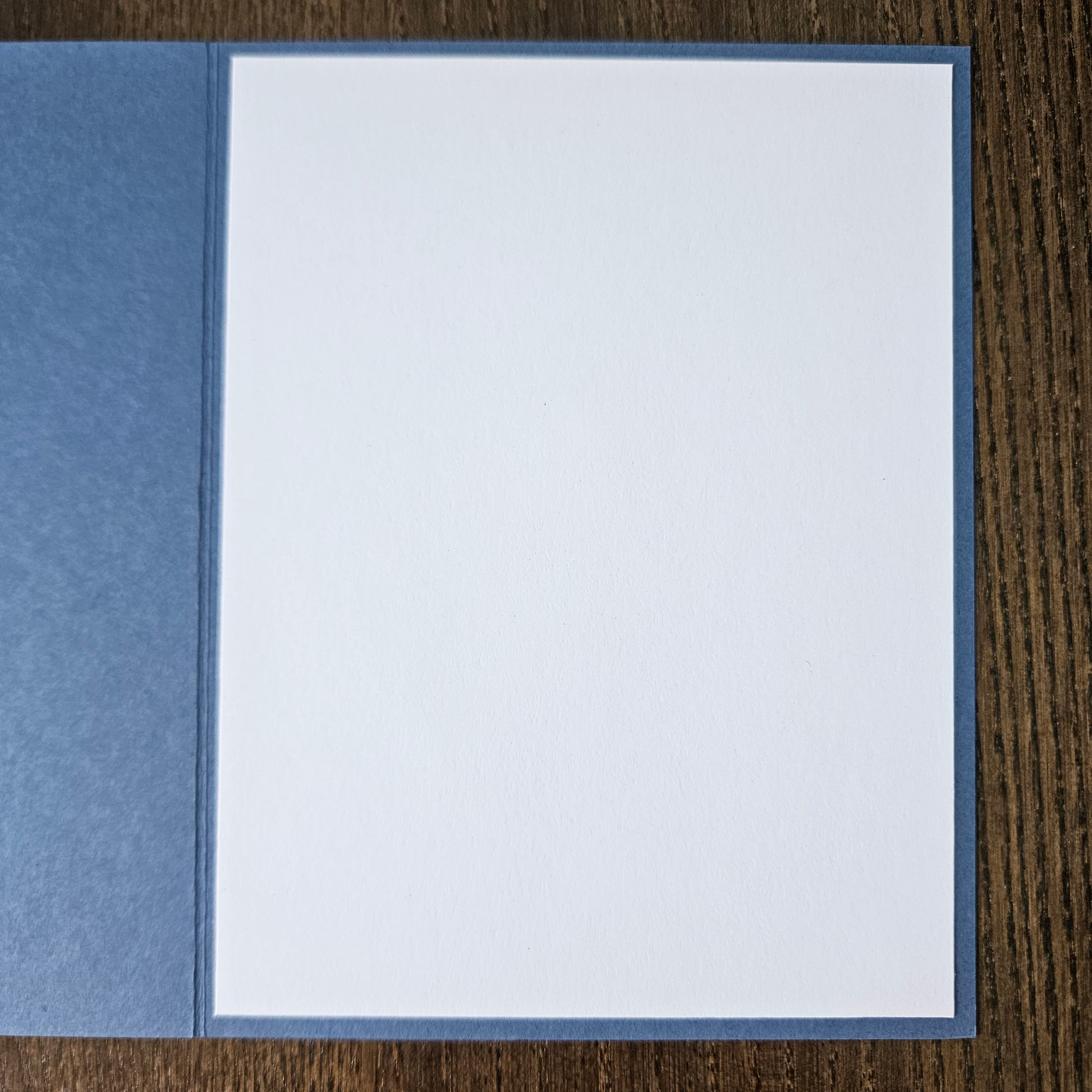 White card with blue border on a wooden surface