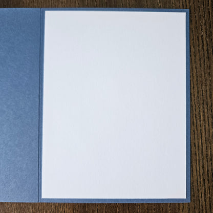 White card with blue border on a wooden surface