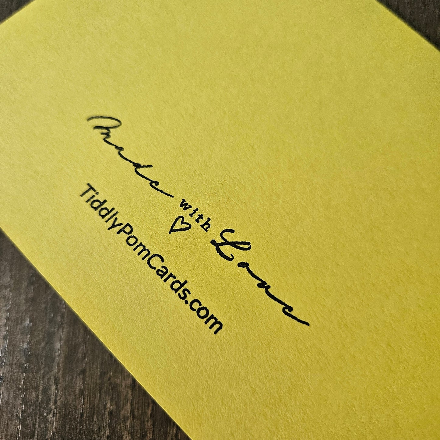 Yellow card with 'Made with Love' and 'TiddlyPonCards.com' text on a wooden surface