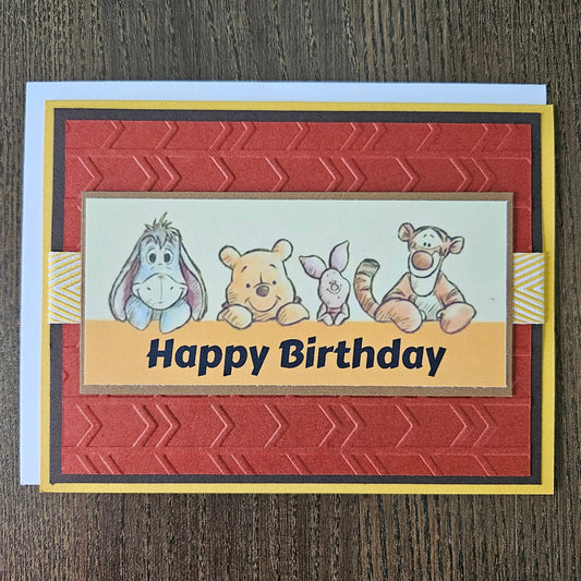 Birthday card with cartoon characters and 'Happy Birthday' text on a wooden surface