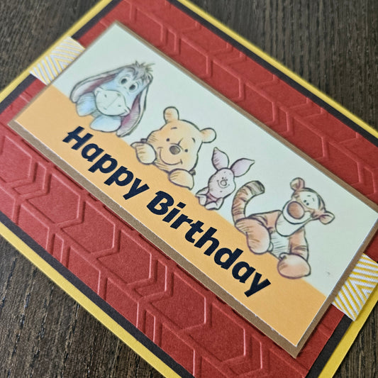 Birthday card with cartoon characters and 'Happy Birthday' text on a textured surface