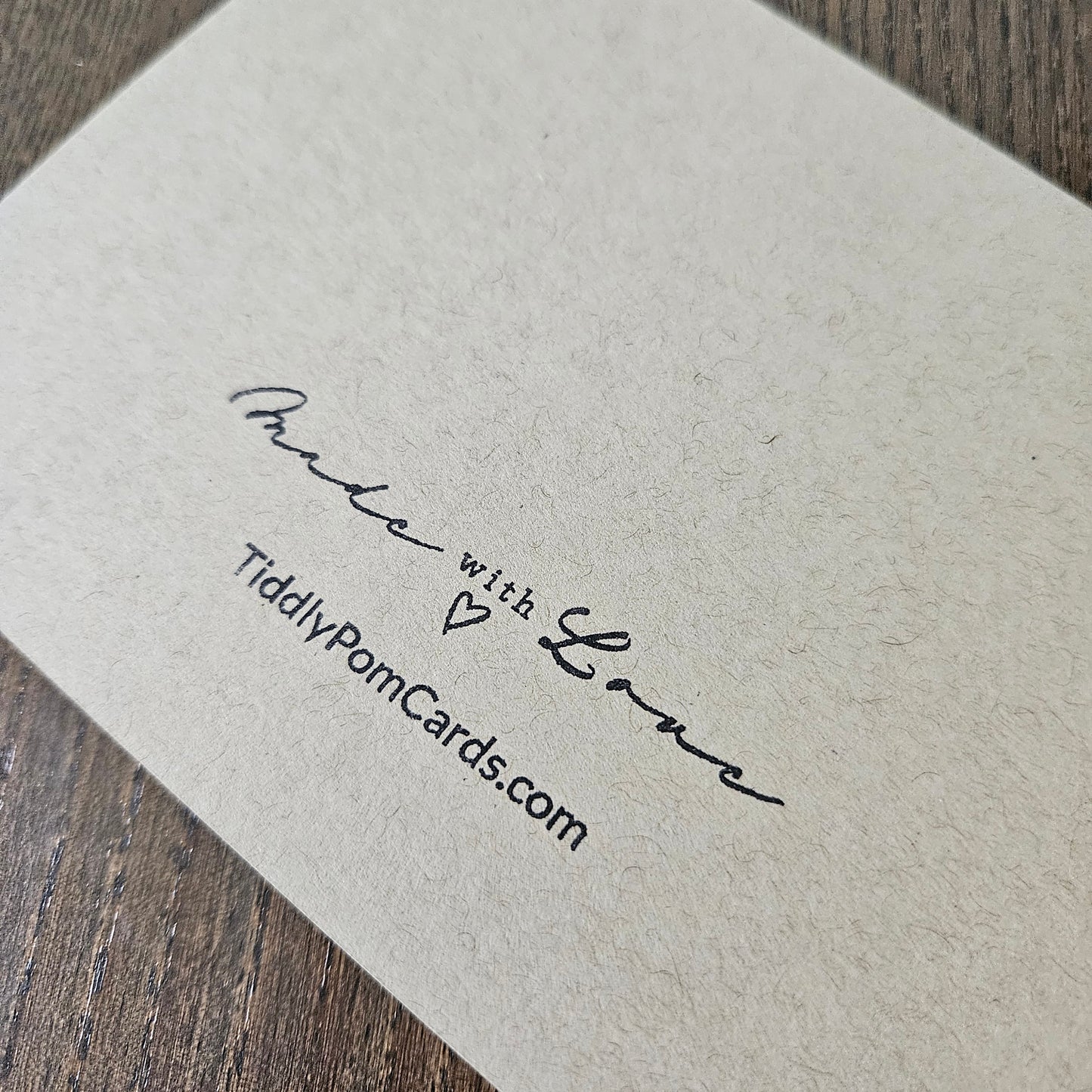 Card with 'Made with Love' text and website address on textured paper