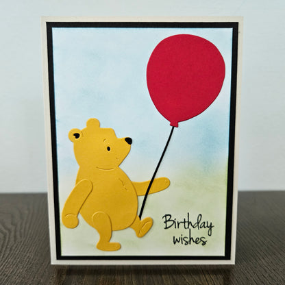 Card with a bear holding a red balloon and 'Birthday wishes' text on a gradient background.