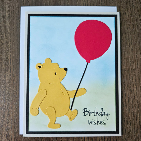 Cartoon bear with a red balloon on a birthday card