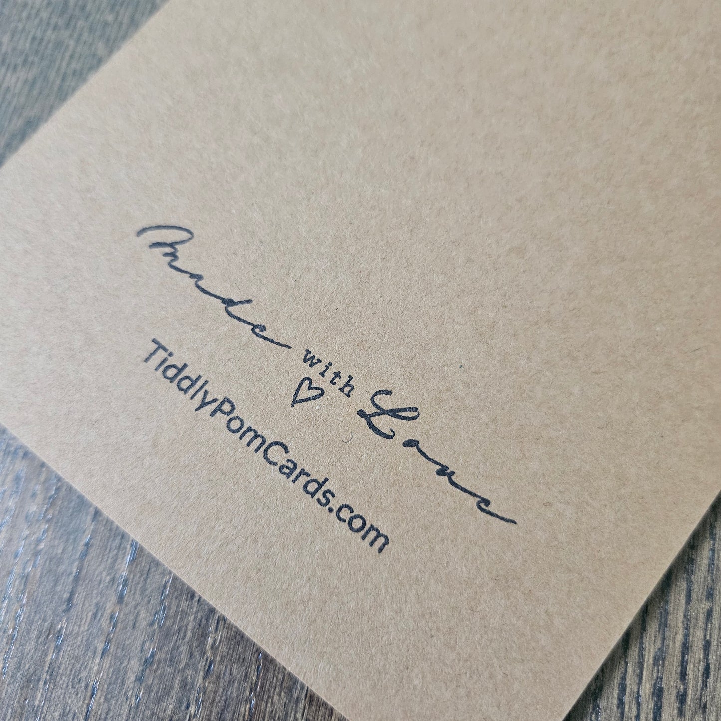 Kraft paper card with 'Made with Love' and 'TiddlyPomCards.com' text on a wooden surface