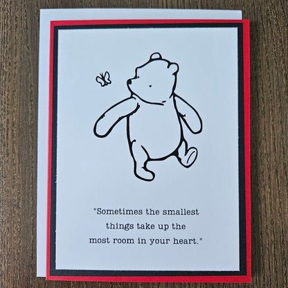 Card with a bear illustration and text on a wooden surface