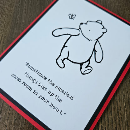 Card with a bear illustration and text on a wooden surface