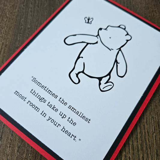 Card with a bear illustration and text on a wooden surface
