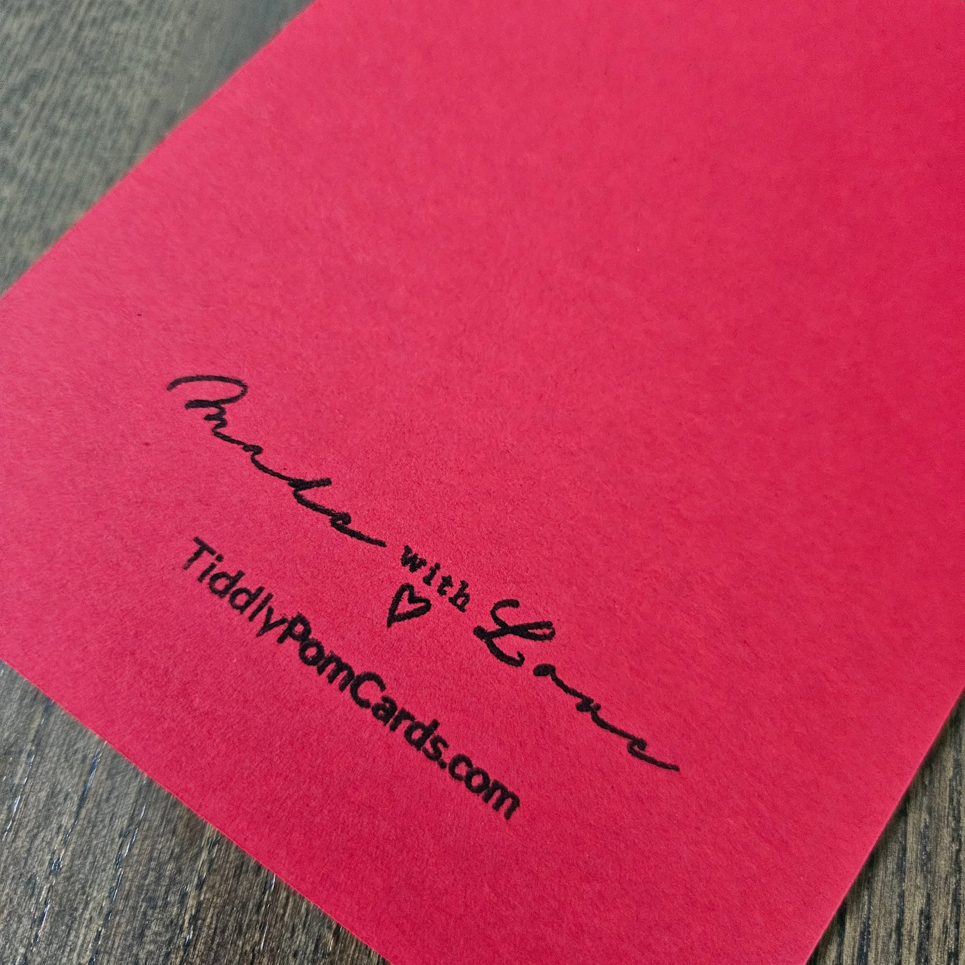 Red card with 'Made with Love' and 'TiddlyPomCards.com' text on a wooden surface