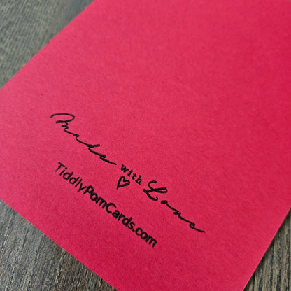 Red card with 'Made with Love' and 'TiddlyPomCards.com' text on a wooden surface