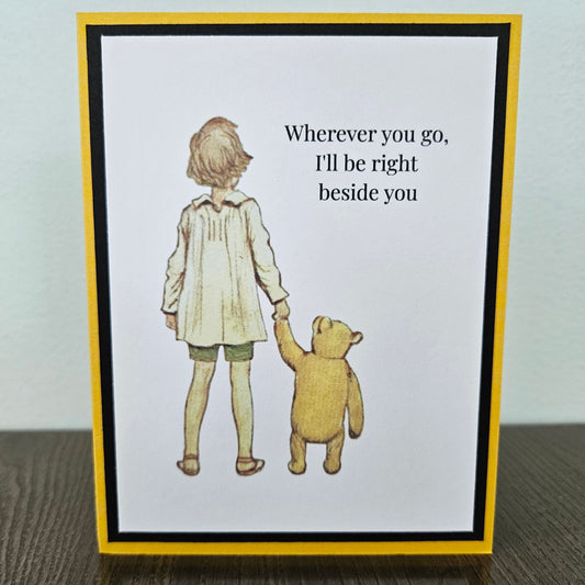 Greeting card with illustration of a child and bear holding hands and text 'Wherever you go, I'll be right beside you'.