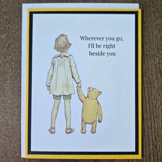 Greeting card with illustration of a child and bear holding hands on a wooden surface