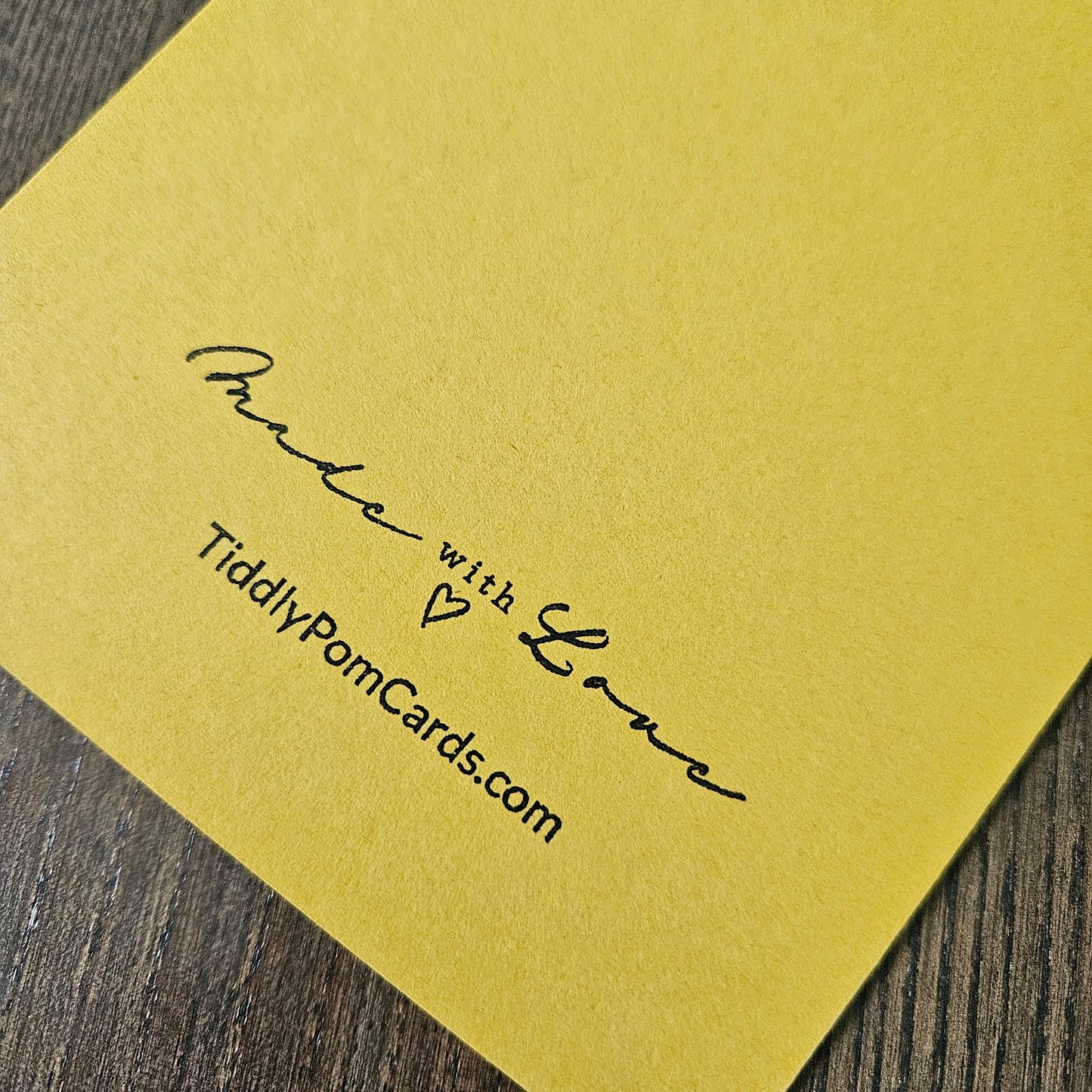 Yellow card with 'Made with Love' text on a wooden surface