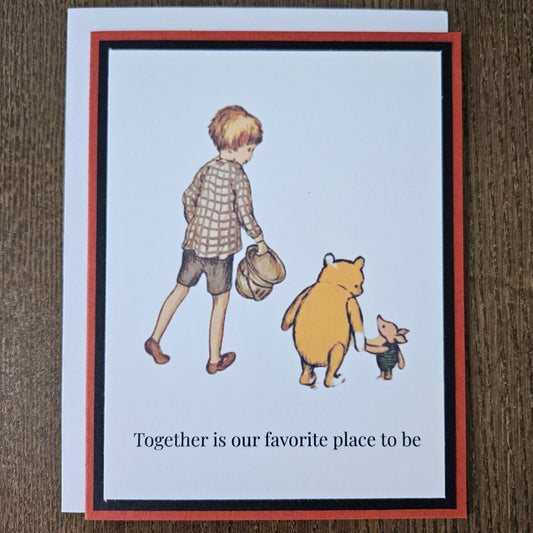 Card with illustrations of a boy, bear, and mouse with text on a wooden surface