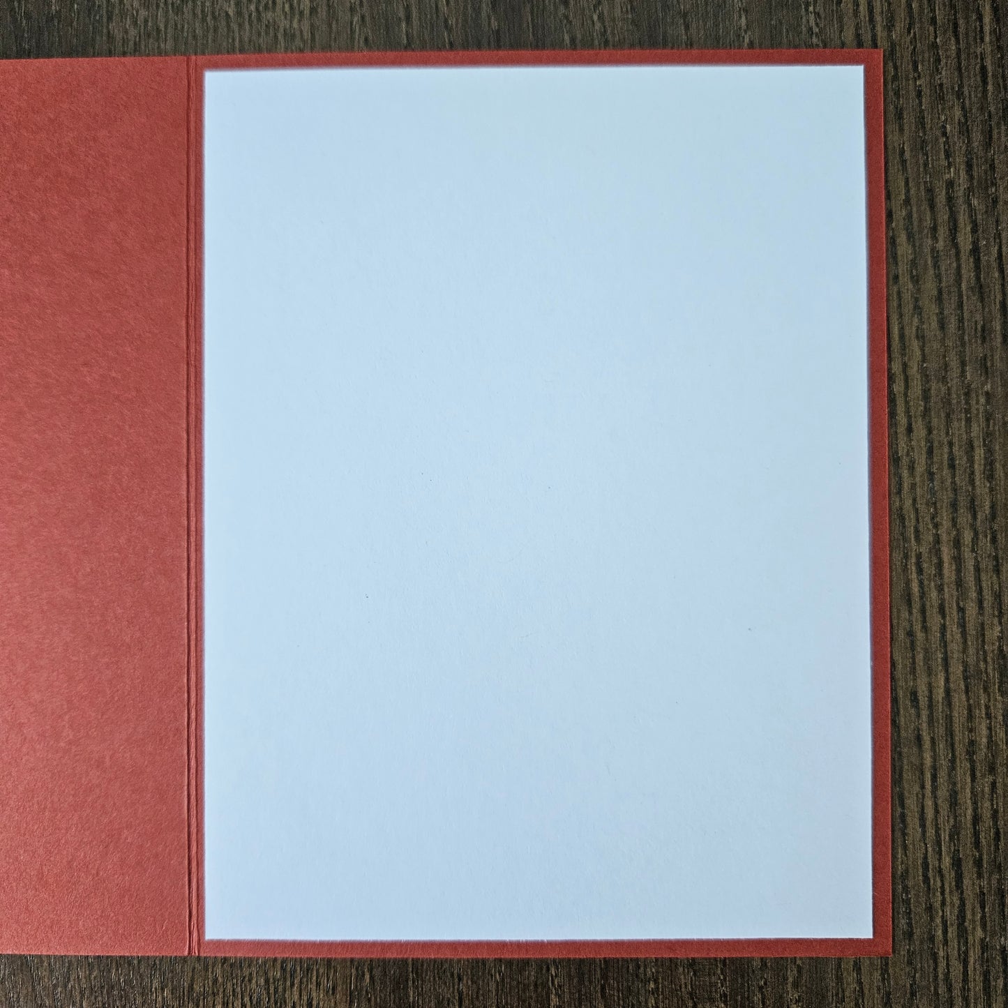 Red card with a white square on a wooden surface