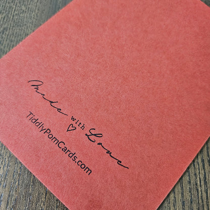 Red card with 'Made with Love' and 'TiddlyPomCards.com' text on a wooden surface