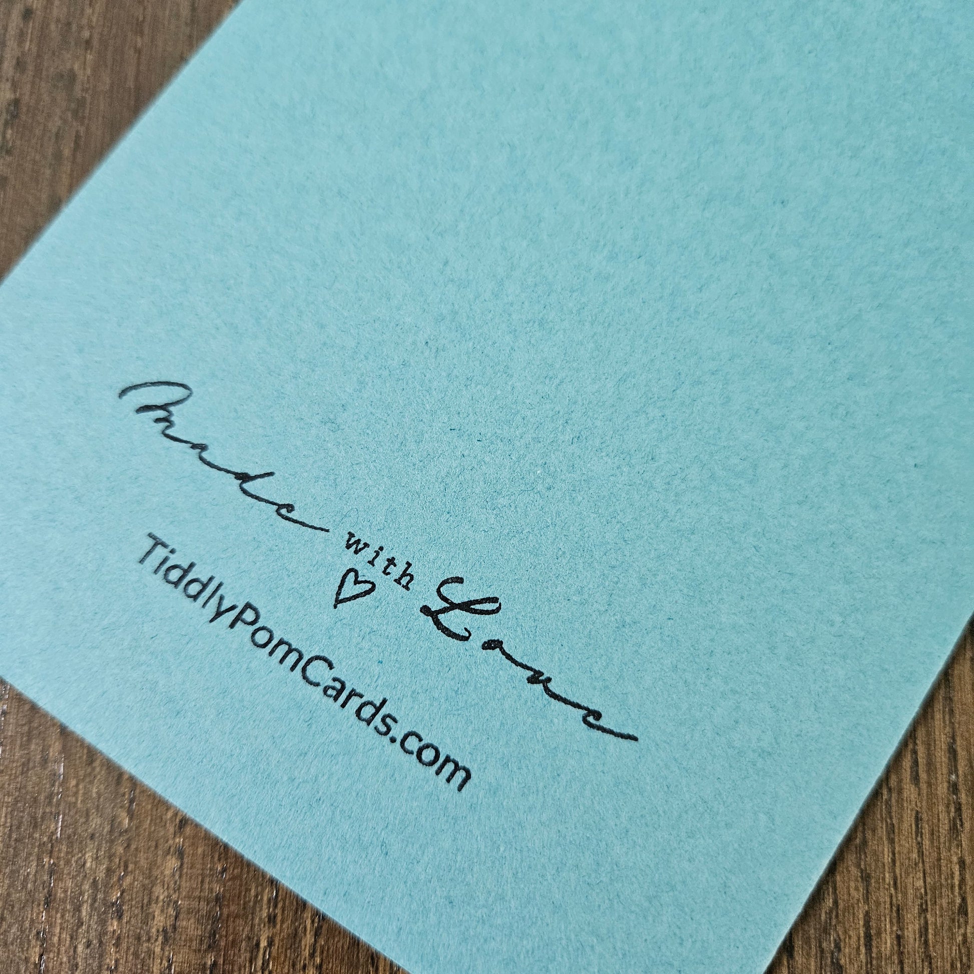 Light blue card with 'Made with Love' and TiddlyPamCards.com text on a wooden surface