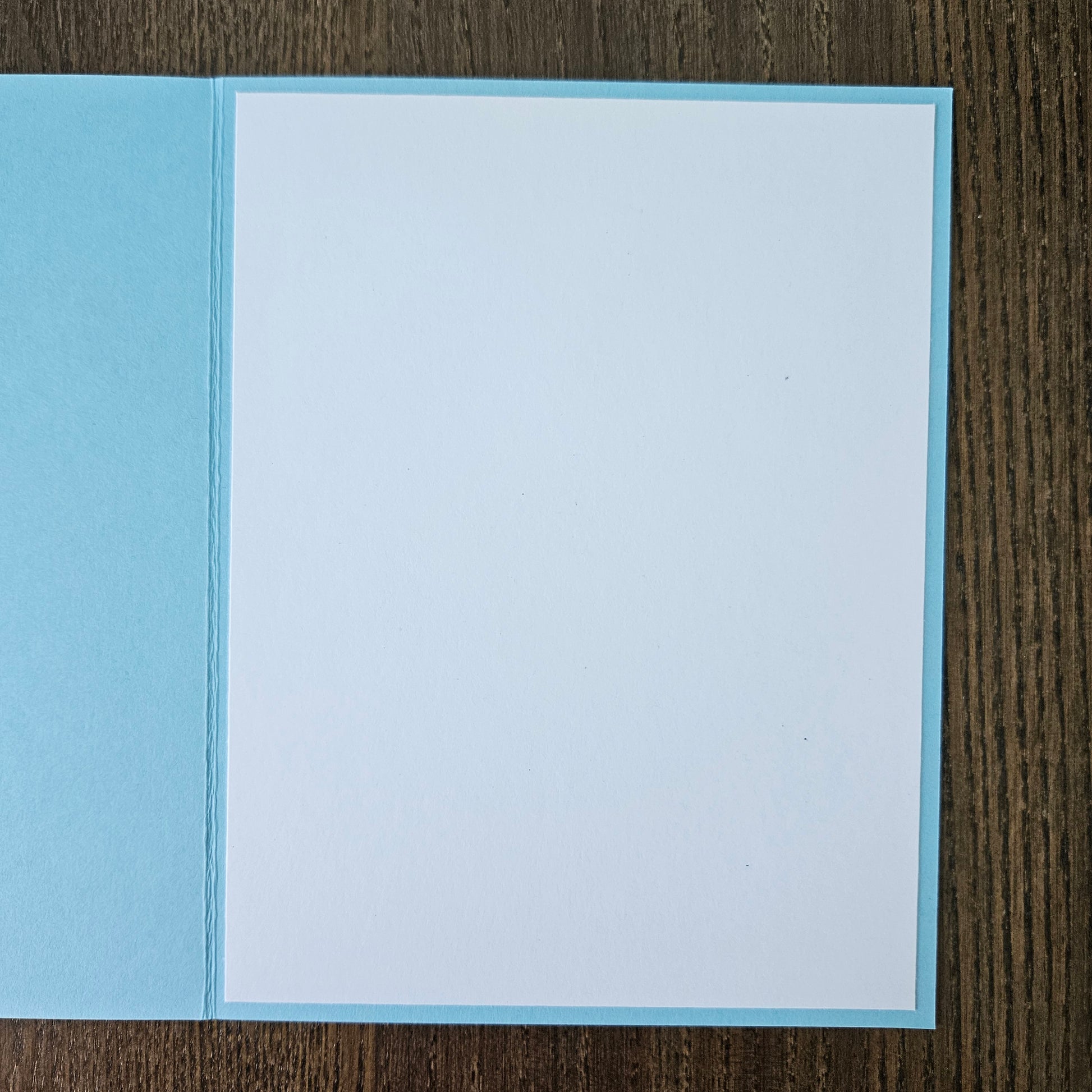 Blue and white card on a wooden surface
