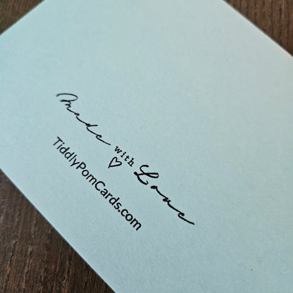 Light blue card with black text on a wooden surface