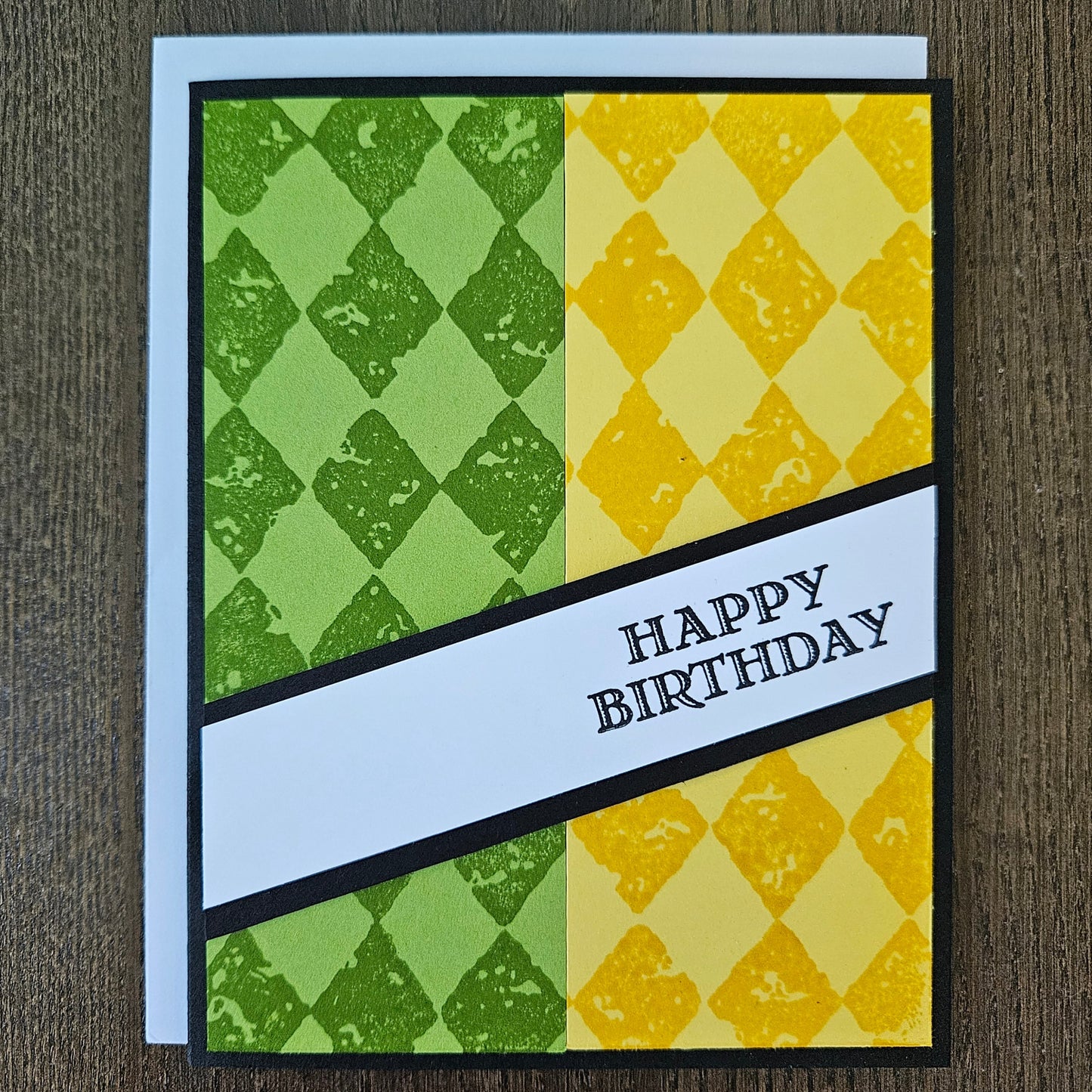 Handmade birthday card for him with green and yellow argyle stamped panels and diagonal banner on black border. Text reads Happy Birthday.