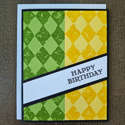 Handmade birthday card for him with green and yellow argyle stamped panels and diagonal banner on black border. Text reads Happy Birthday.