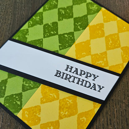 Birthday card with green and yellow checkered pattern and 'Happy Birthday' text.