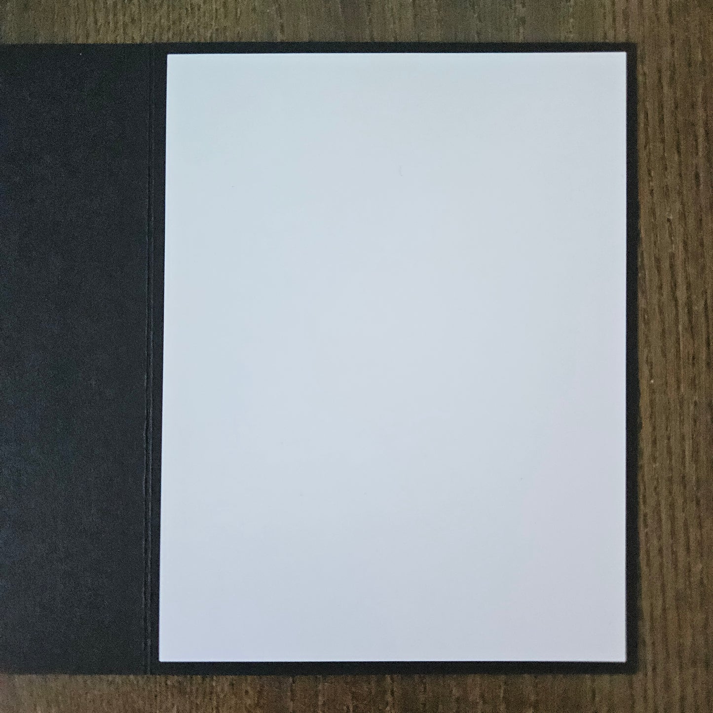 White card with black border on a wooden surface