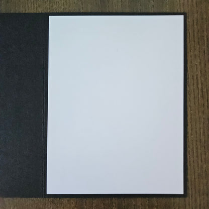 White card with black border on a wooden surface