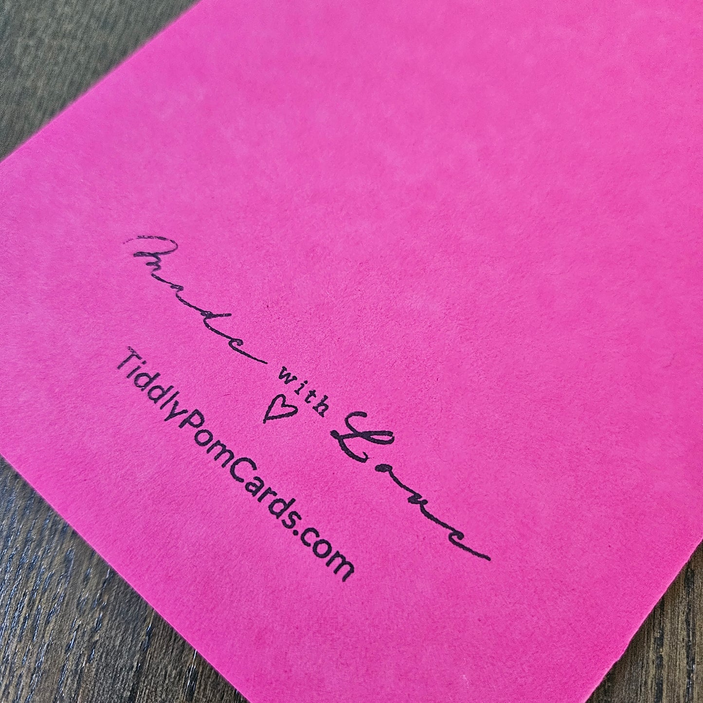 Pink card with 'Made with Love' and 'TiddlyPomCards.com' text on a wooden surface