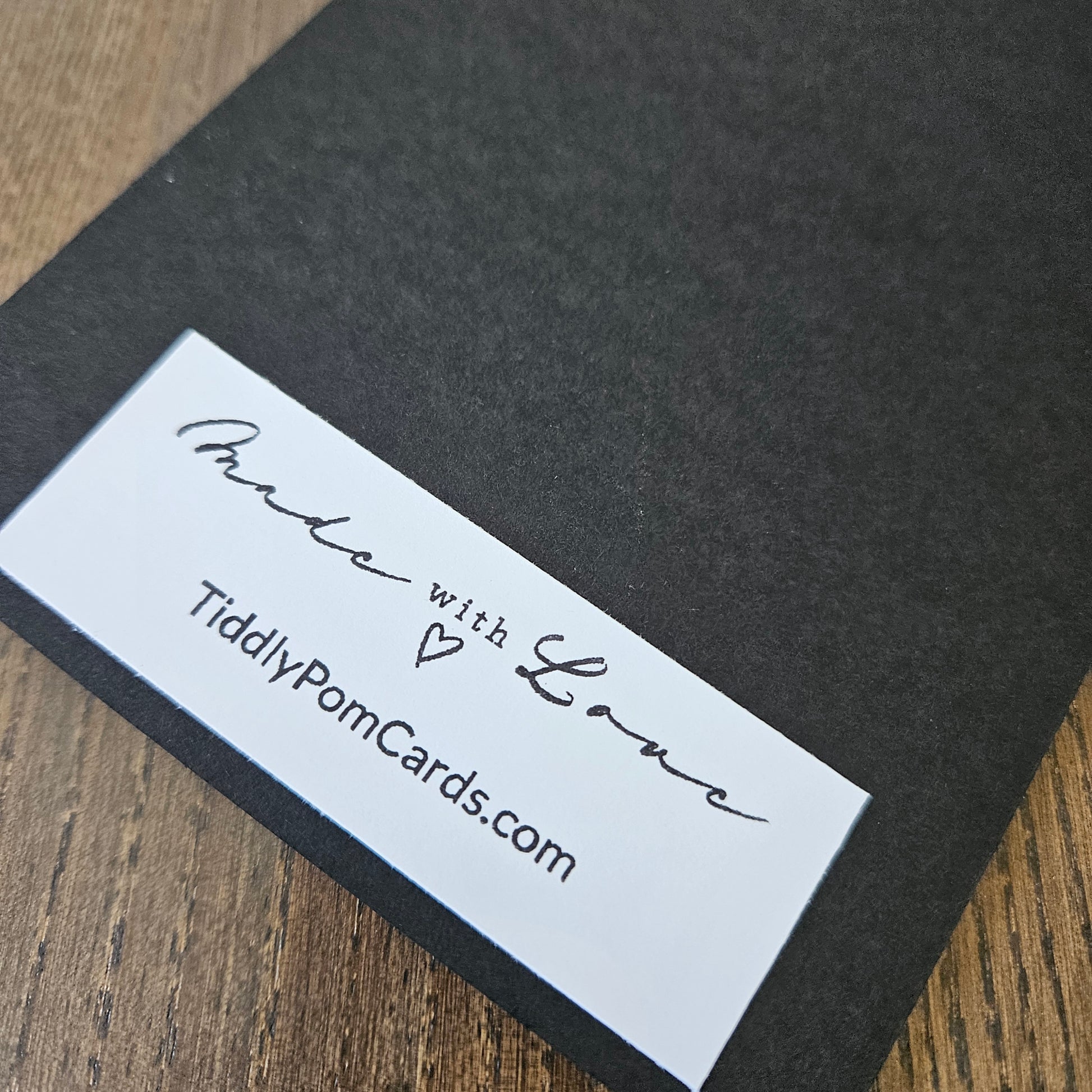 Black card with white label on a wooden surface