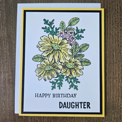 Handmade birthday card for daughter featuring a hand-colored cluster of yellow daisies and tiny pink flowers on a layered white, black, and bright yellow cardstock frame. Bold text reads HAPPY BIRTHDAY DAUGHTER.
