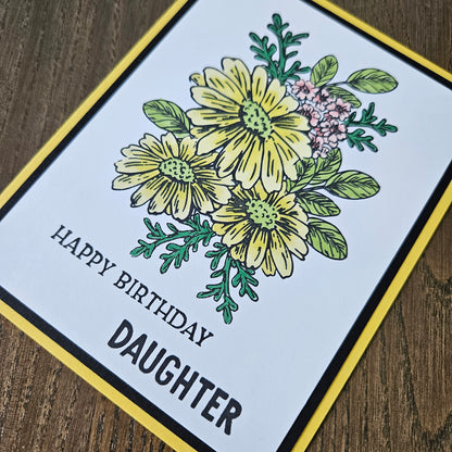 Greeting card with floral design and 'Happy Birthday Daughter' text on a wooden surface