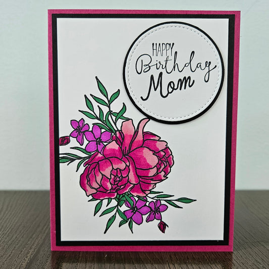 Handmade birthday card for mom with hand-colored magenta and purple peony bouquet and layered die-cut circle sentiment on white inner panel with black and hot pink border. Text reads Happy Birthday Mom.