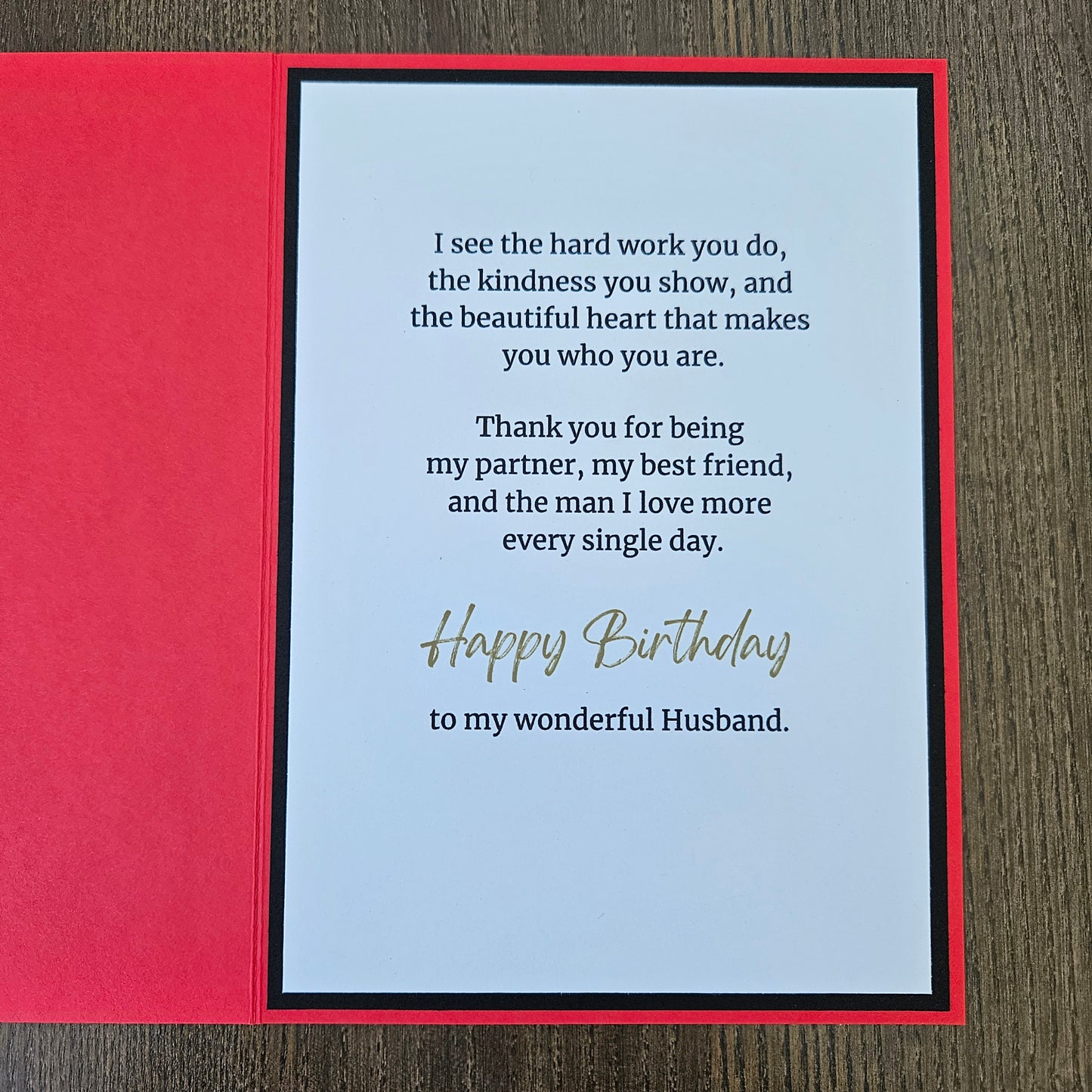 The inside of the handmade birthday card for husband from wife showing a clean white insert with a printed emotional birthday message, framed by a black inner border against a bright red card stock background.