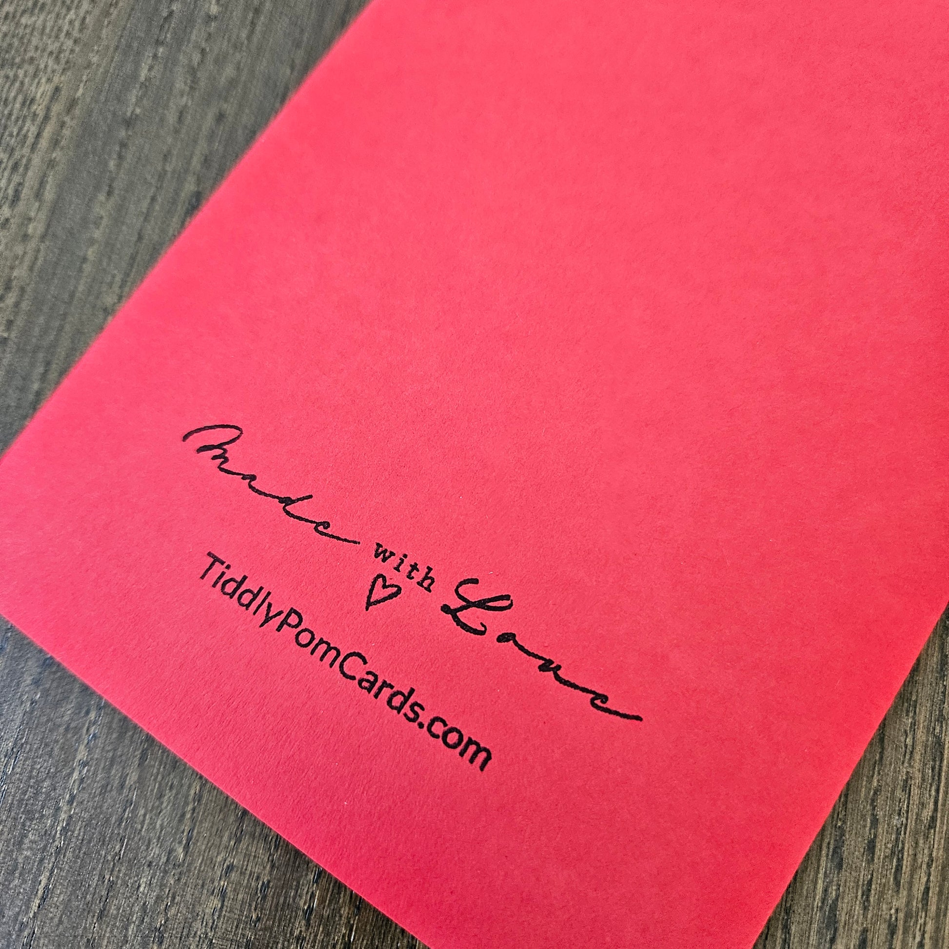 Red card with 'Made with Love' and TiddlyPomCards.com text on a wooden surface