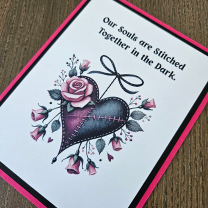 Card with a purple heart, roses, and text on a wooden surface